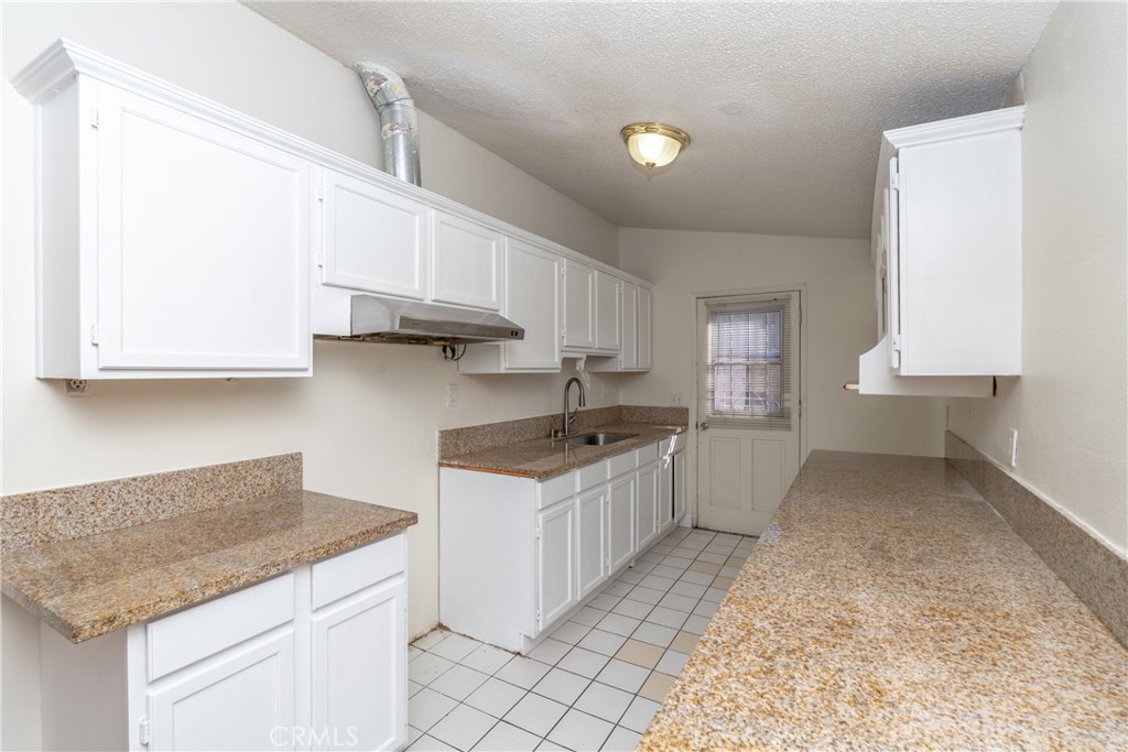 16302 Rochlen Street Hacienda Heights, CA 91745 - Photo 12 of 17 a kitchen with stainless steel appliances granite countertop a sink stove and cabinets
