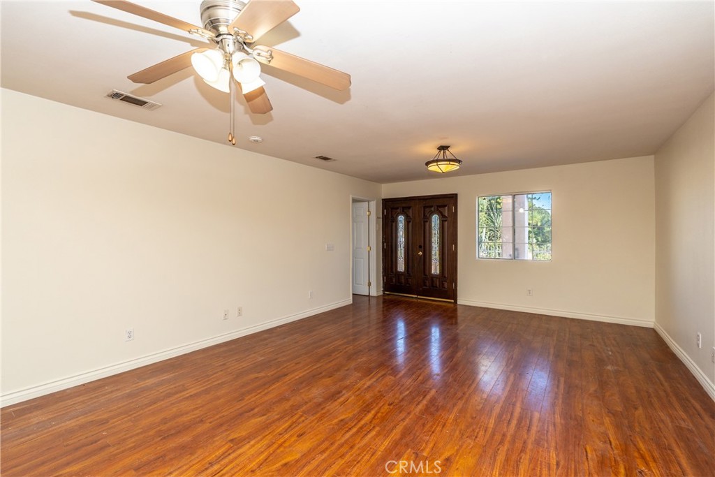 16302 Rochlen Street Hacienda Heights, CA 91745 - Photo 3 of 17 an empty room with wooden floor chandelier fan and windows