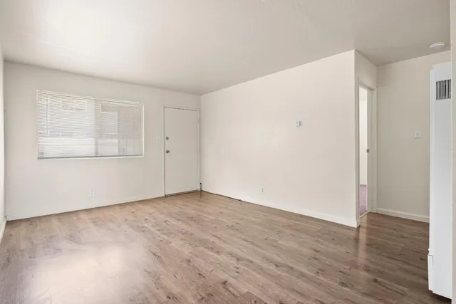 a view of an empty room with wooden floor