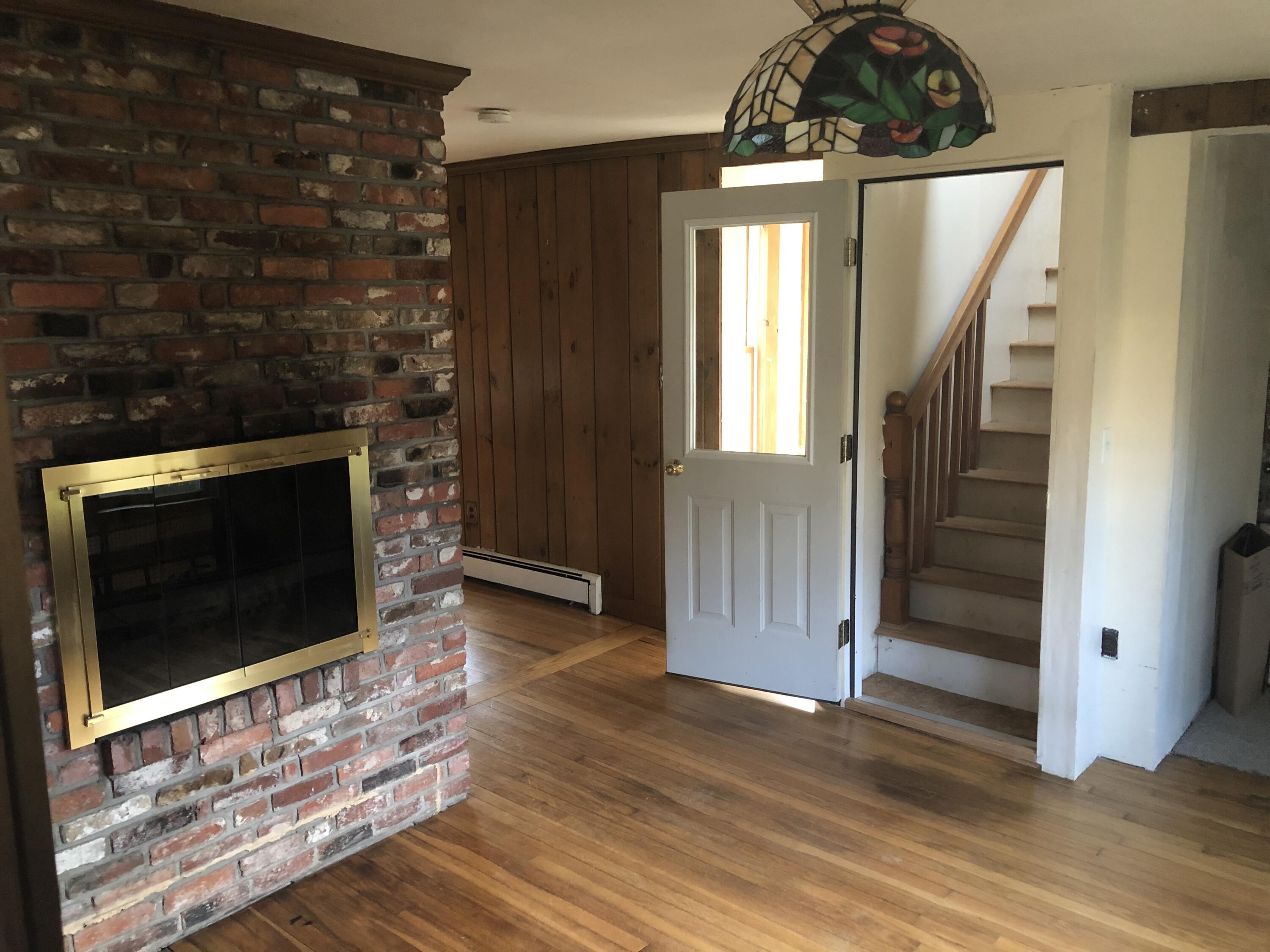 347 Santuit-Newtown Road Marstons Mills, MA 02648 - Photo 3 of 26 a view of a livingroom with wooden floor and a fireplace