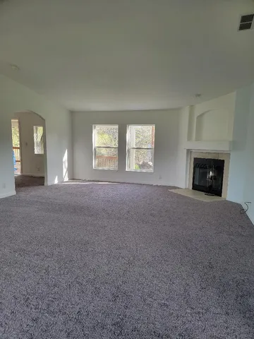 a view of empty room with a fireplace