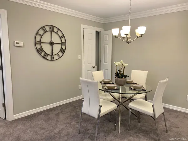 a view of a dining room with furniture and a chandelier