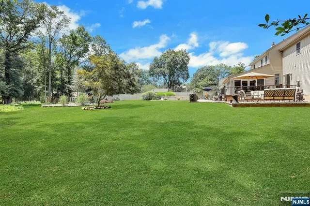 a front view of a house with garden and trees