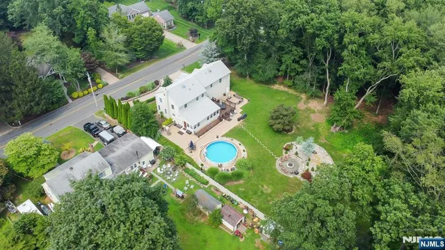 an aerial view of a house with a garden and lake view