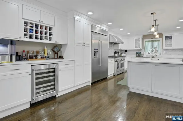 a kitchen with stainless steel appliances kitchen island hardwood floor sink and stove