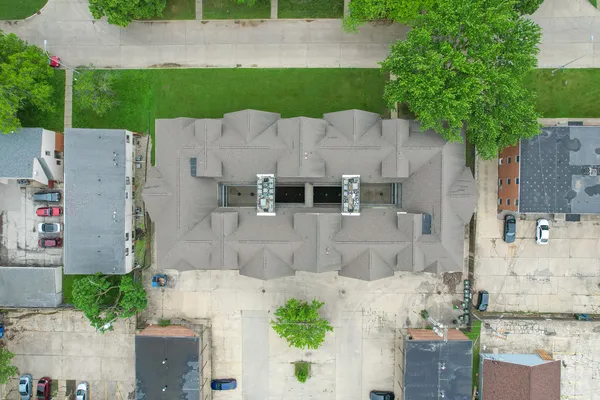 an aerial view of a house with a yard and large tree