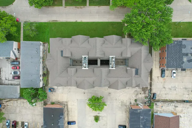 an aerial view of a house with a yard and large tree