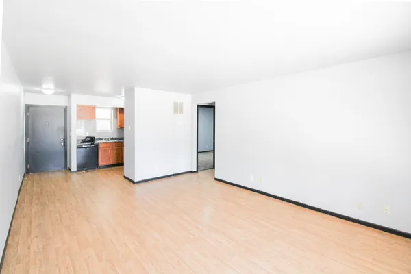 a view of empty room with kitchen