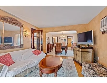 a living room with furniture a flat screen tv and a kitchen