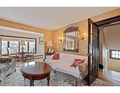 a living room with furniture a wooden floor and a large window