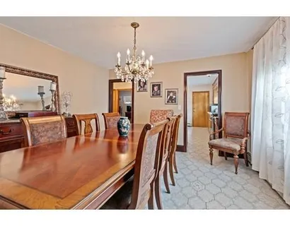 a dining room with furniture a chandelier and wooden floor