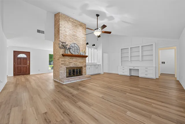 a view of empty room with a fireplace and wooden floor