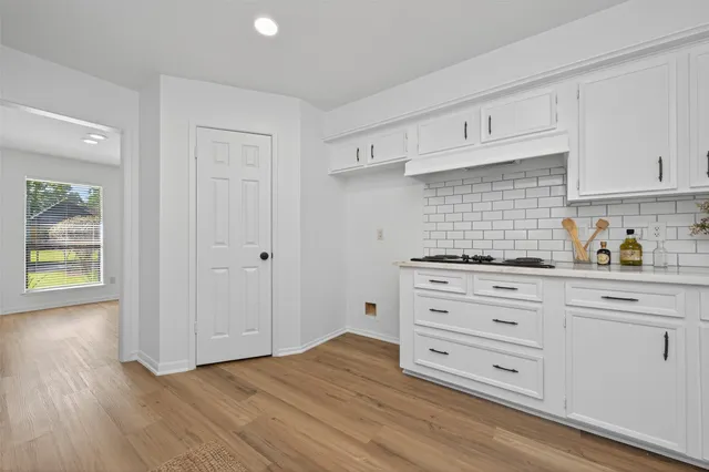 a kitchen with granite countertop white cabinets and white appliances