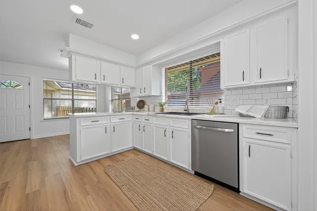 a kitchen with appliances cabinets a sink and a window