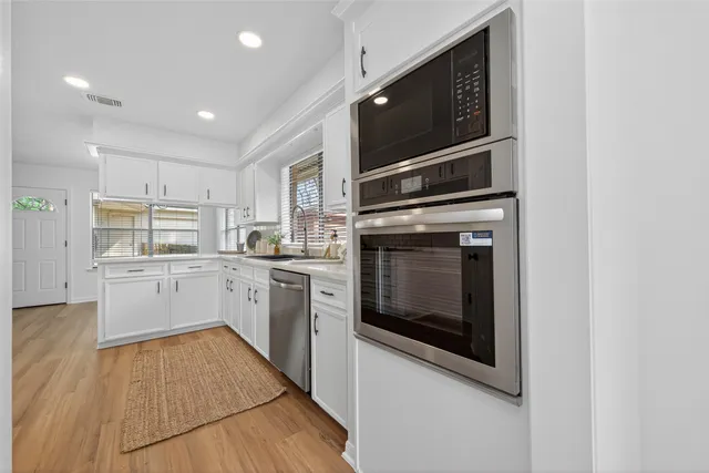a kitchen with granite countertop a stove top oven and cabinets
