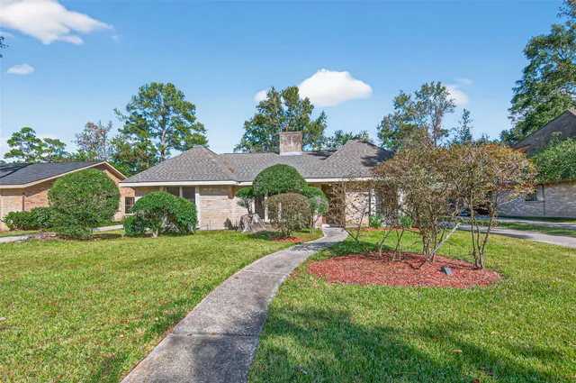 a garden with a bench in front of the house