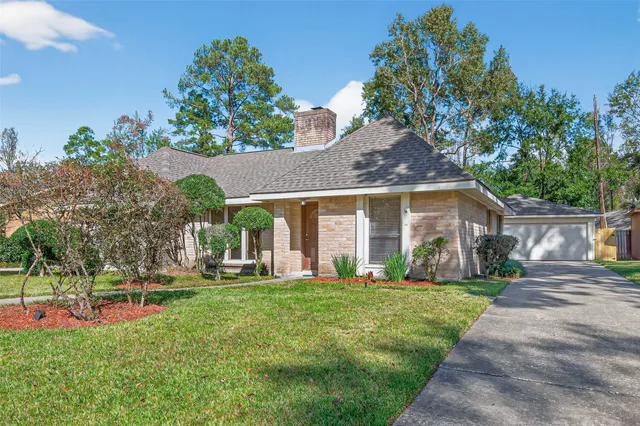 a front view of a house with a yard and trees