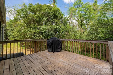a balcony with wooden floor and yard in the back