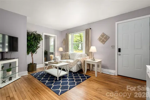 a living room with furniture a flat screen tv and a table