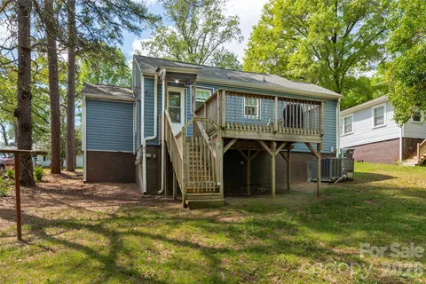a view of a house with backyard and a tree