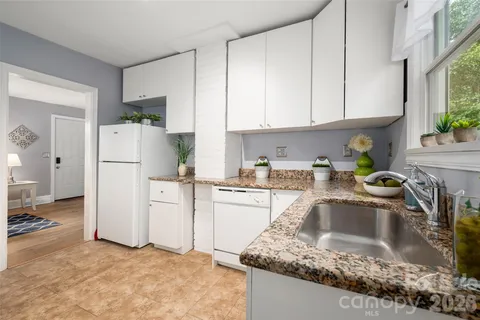 a kitchen with a refrigerator sink stove and white cabinets