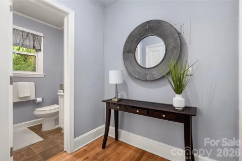 a living room with a toilet a mirror and a window