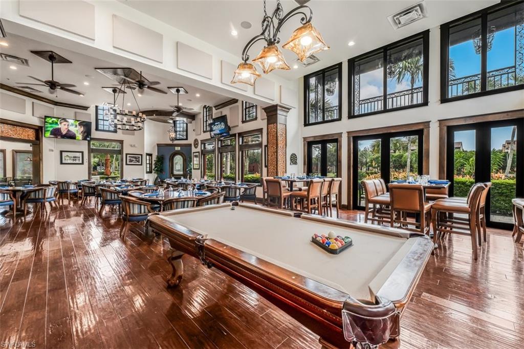 9147 Delano Street, Unit 9605 Naples, FL 34113 - Photo 24 of 27 a room with lots of tables a large window and chairs