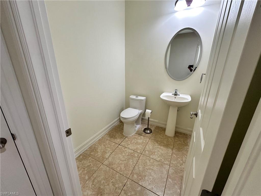 9147 Delano Street, Unit 9605 Naples, FL 34113 - Photo 6 of 27 a bathroom with a toilet sink and mirror