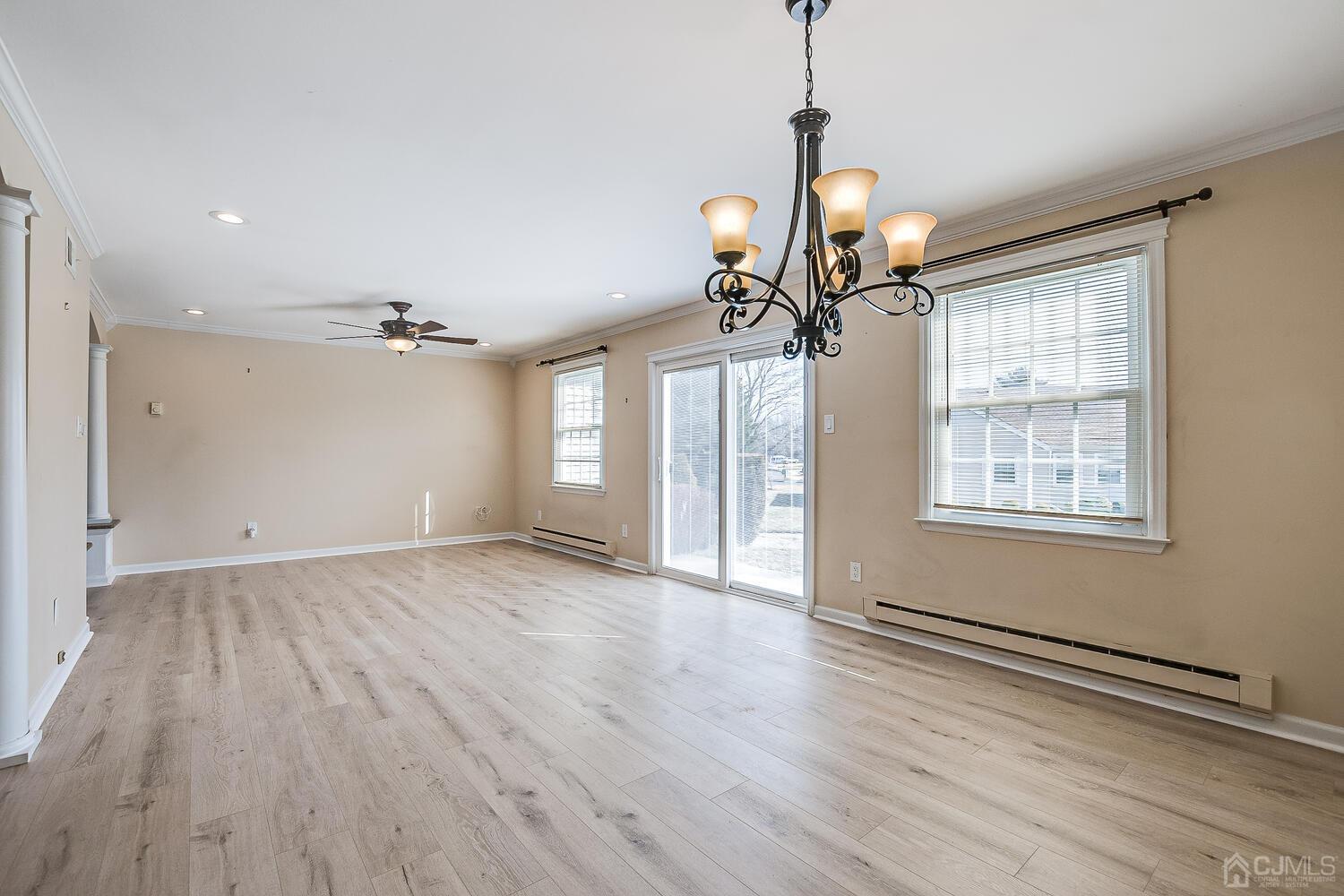 85 Jamestown Road, Unit B Freehold, NJ 07728 - Photo 12 of 36 a view of a livingroom with wooden floor and a ceiling fan