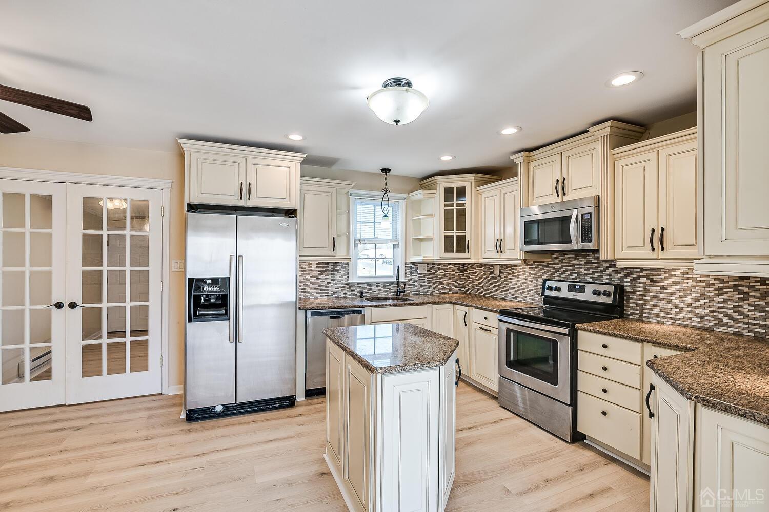 85 Jamestown Road, Unit B Freehold, NJ 07728 - Photo 15 of 36 a kitchen with stainless steel appliances granite countertop a refrigerator stove and sink