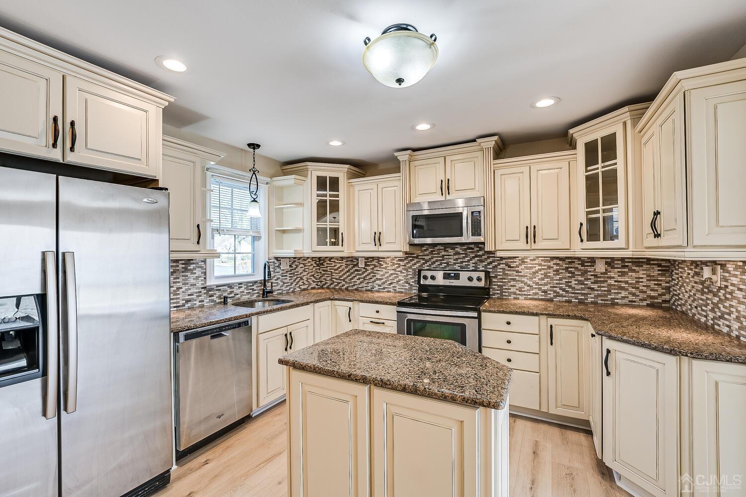 85 Jamestown Road, Unit B Freehold, NJ 07728 - Photo 17 of 36 a kitchen with stainless steel appliances granite countertop a refrigerator stove microwave and sink