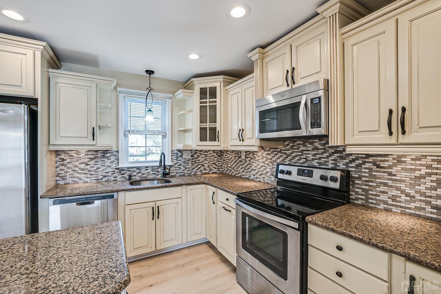 85 Jamestown Road, Unit B Freehold, NJ 07728 - Photo 19 of 36 a kitchen with stainless steel appliances granite countertop a sink stove oven and white cabinets