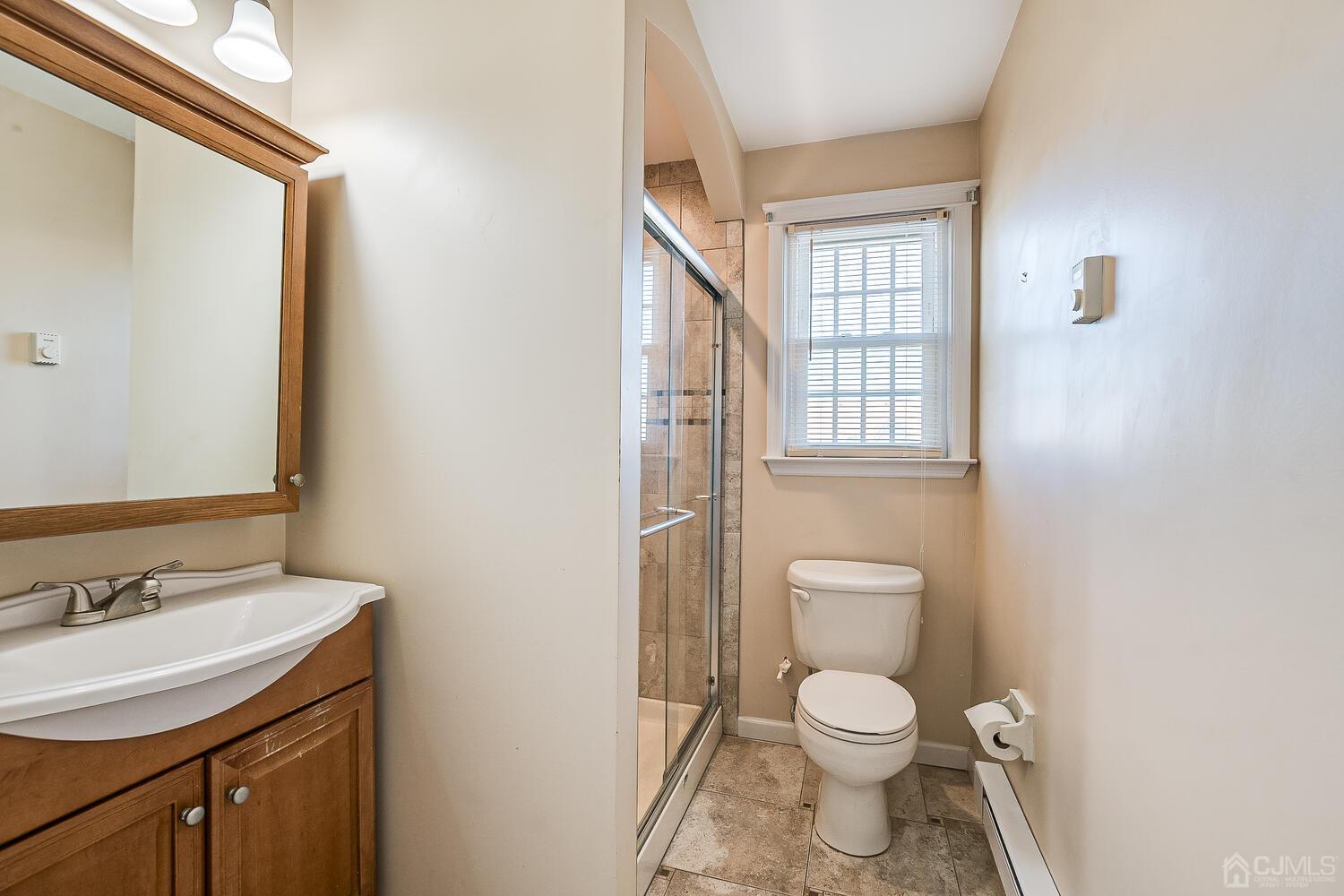 85 Jamestown Road, Unit B Freehold, NJ 07728 - Photo 27 of 36 a bathroom with a toilet a sink and a mirror