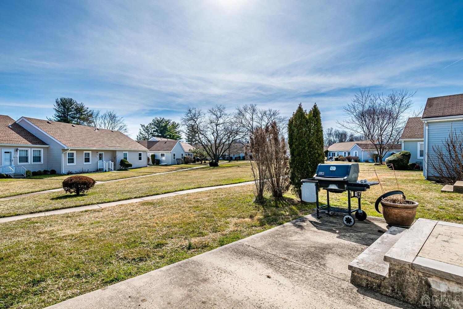 85 Jamestown Road, Unit B Freehold, NJ 07728 - Photo 35 of 36 a view of a swimming pool with lawn chairs and a yard