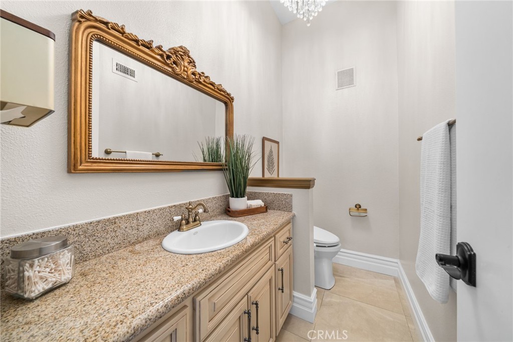 2487 Cliff Road Upland, CA 91784 - Photo 16 of 49 a bathroom with a granite countertop sink a toilet and a mirror