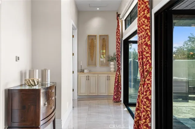 a view of a hallway with a dining table & chairs