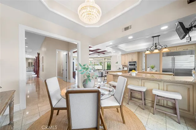 a dining area with a table chairs and a kitchen view