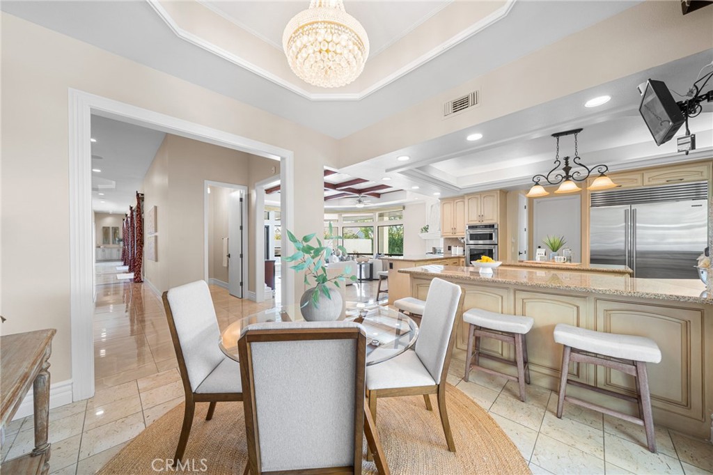 2487 Cliff Road Upland, CA 91784 - Photo 27 of 49 a dining area with a table chairs and a kitchen view