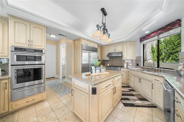 a open kitchen with stainless steel appliances kitchen island granite countertop a stove top oven and cabinets