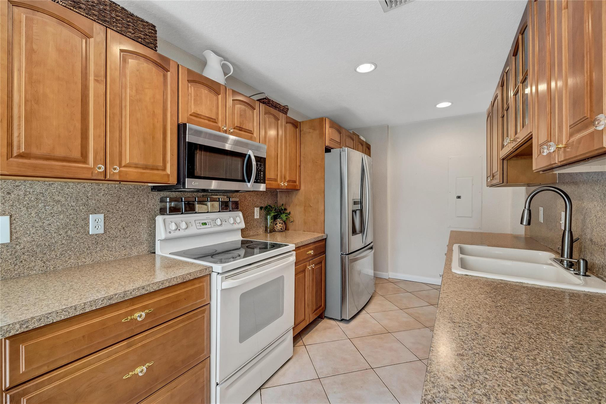 9232 Pecky Cypress Lane, Unit 2D Boca Raton, FL 33428 - Photo 16 of 20 a kitchen with a sink appliances and cabinets