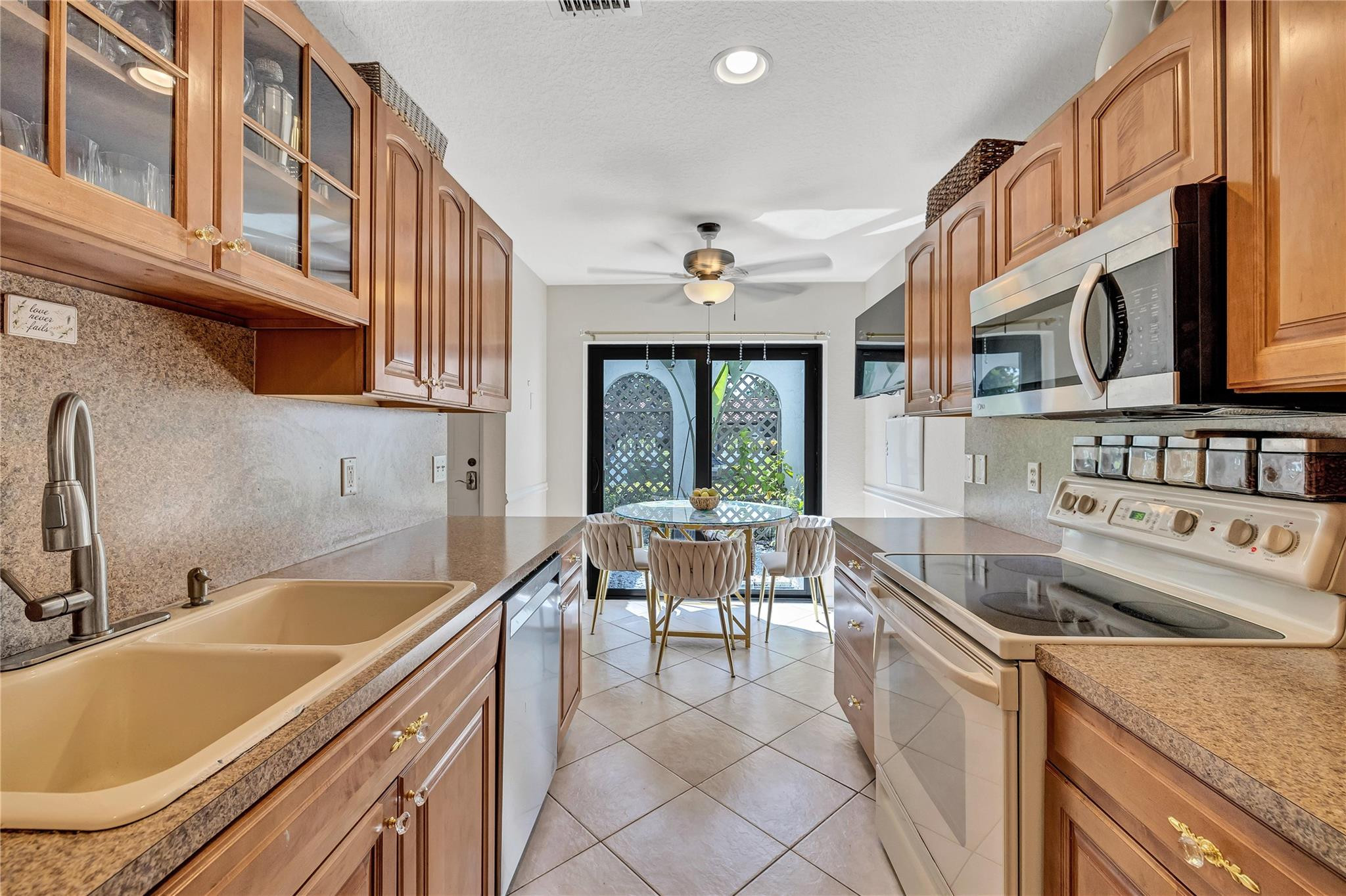 9232 Pecky Cypress Lane, Unit 2D Boca Raton, FL 33428 - Photo 17 of 20 a kitchen that has a sink and chairs
