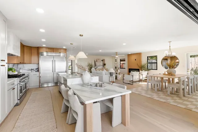 a dining room with furniture a large window and kitchen view