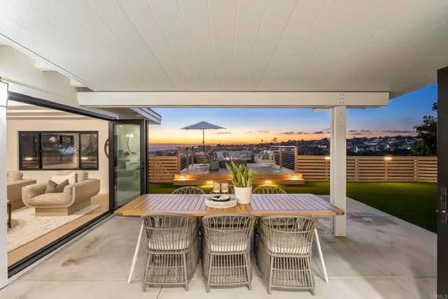 a kitchen with stainless steel appliances granite countertop a stove top oven a sink dishwasher a dining table and chairs with wooden floor