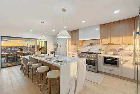 a open kitchen with stainless steel appliances granite countertop a refrigerator stove oven dining table and chairs with wooden floor