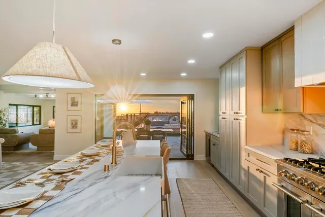 a view of a patio with couches table and chairs under an umbrella