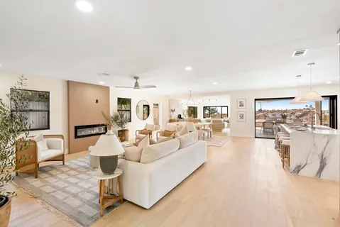 a living room with furniture and a view of kitchen