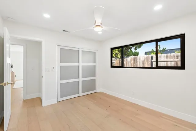 a kitchen with a sink and a refrigerator with white cabinets