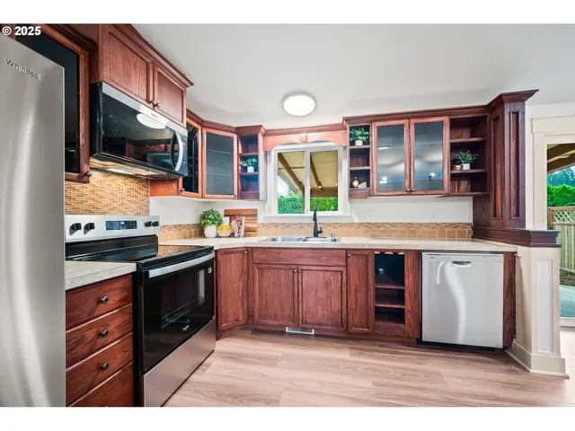 a kitchen with stainless steel appliances granite countertop a stove a sink and a microwave