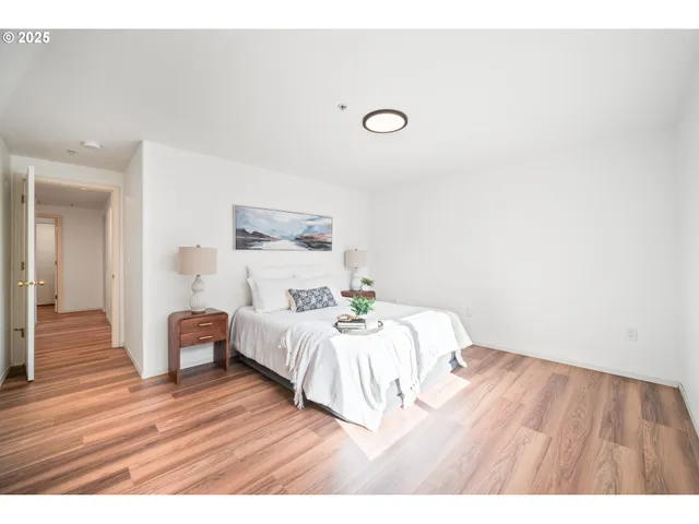 a bedroom with a bed and wooden floor
