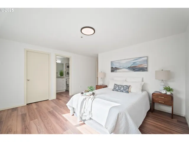 a bedroom with a bed and a painting on the wall